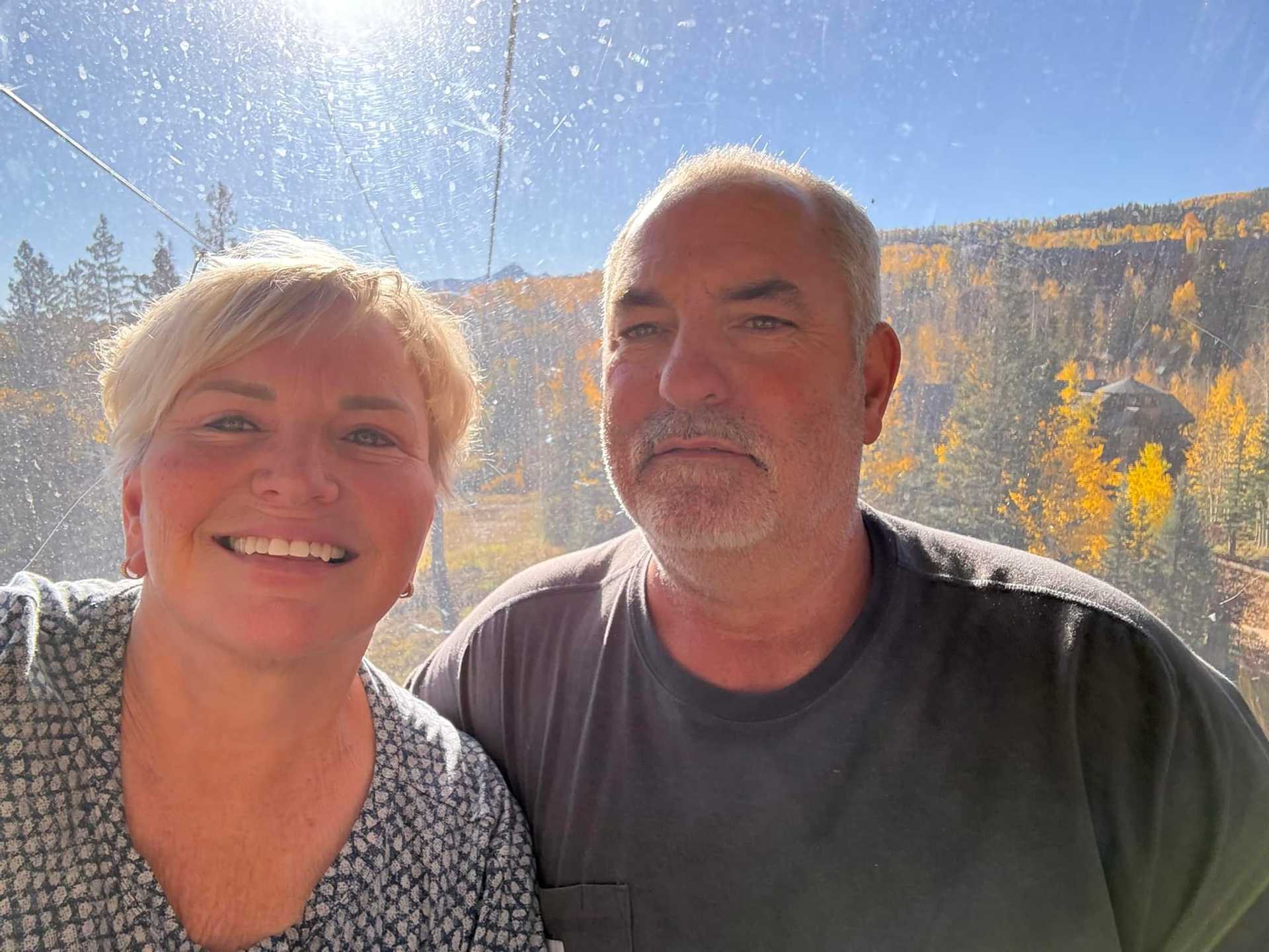 Couple enjoying a sunny day in an autumn forest setting.